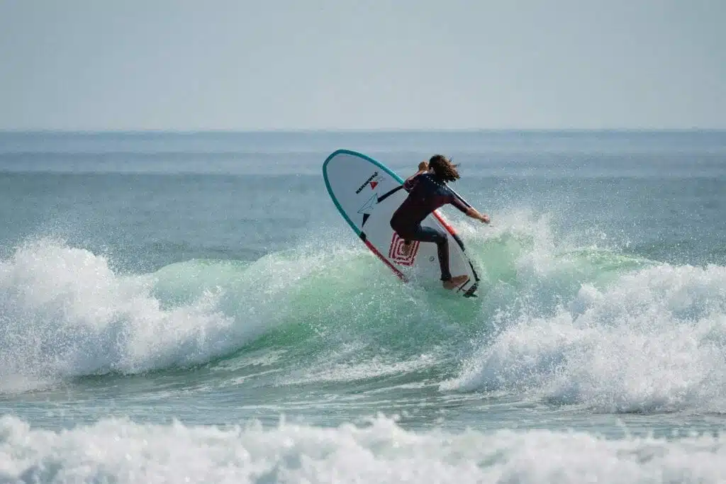 Une personne chevauchant une planche de surf sur une vague